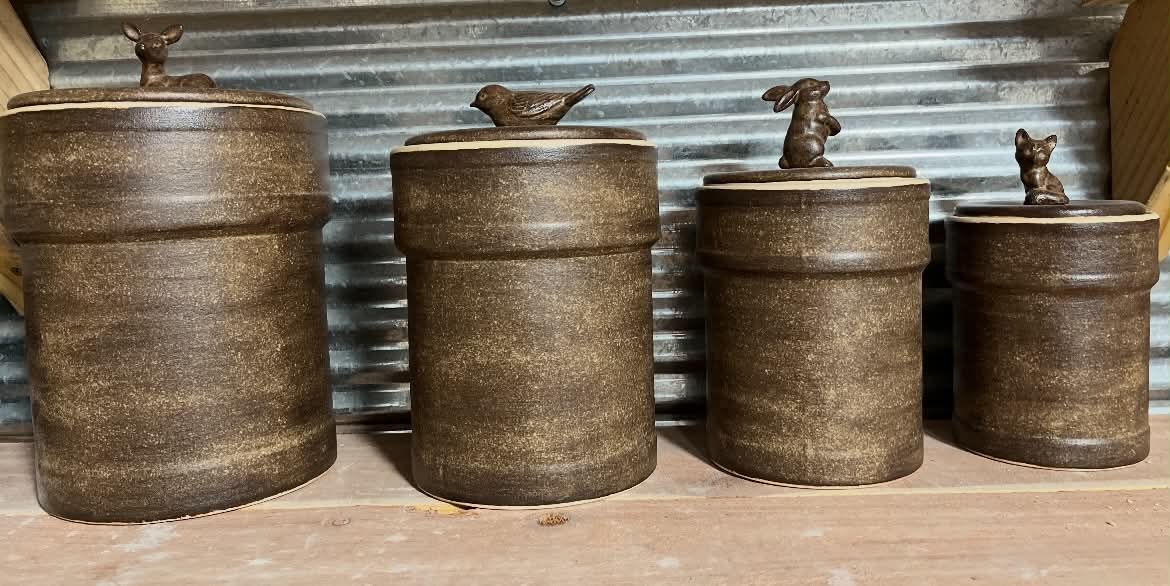 Set of four rustic ceramic canisters with animal lids.